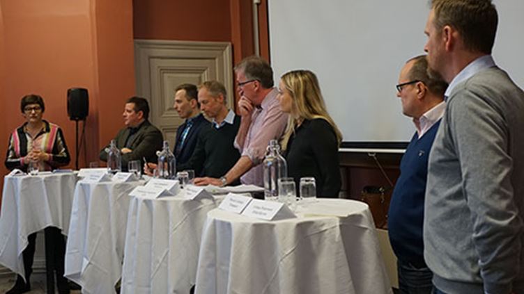 Moderatorn Helle Klein står bredvid seminariepanelen bestående av avtalssekreterare från sex LO-förbund.